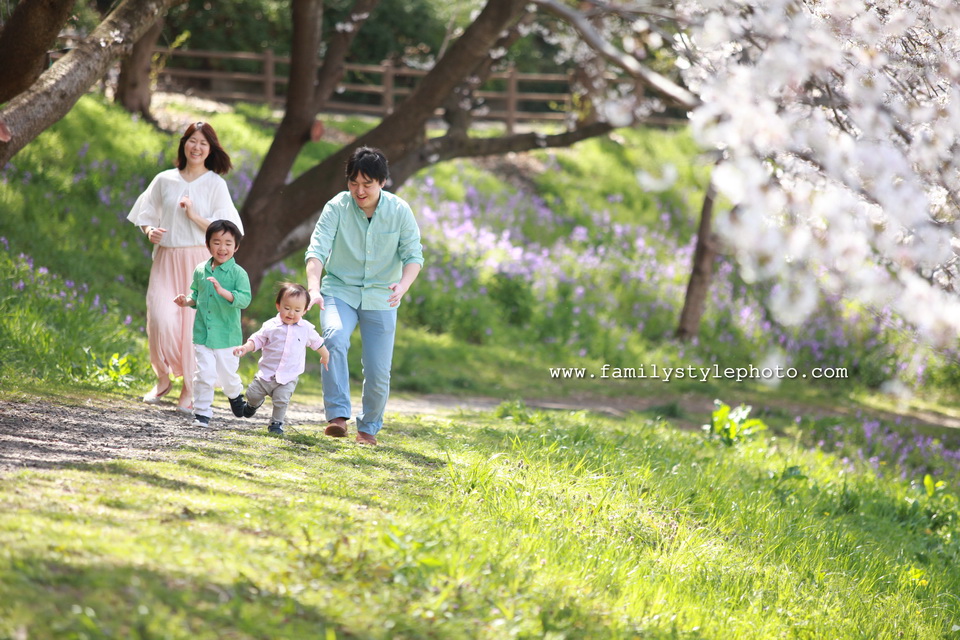 子供たちといっしょに公園を走るパパとママ